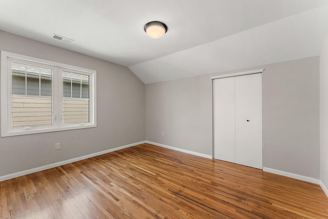 864 Fuller Ave, Saint Paul, MN 55104 - unfurnished bedroom with lofted ceiling, wood finished floors, and a closet