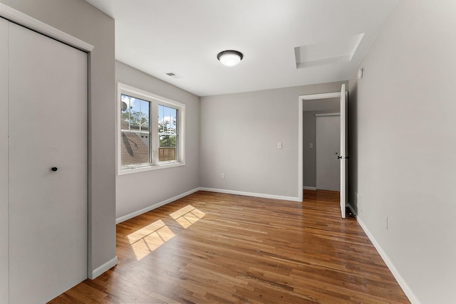 864 Fuller Ave, Saint Paul, MN 55104 - unfurnished bedroom featuring wood finished floors, attic access, and a closet