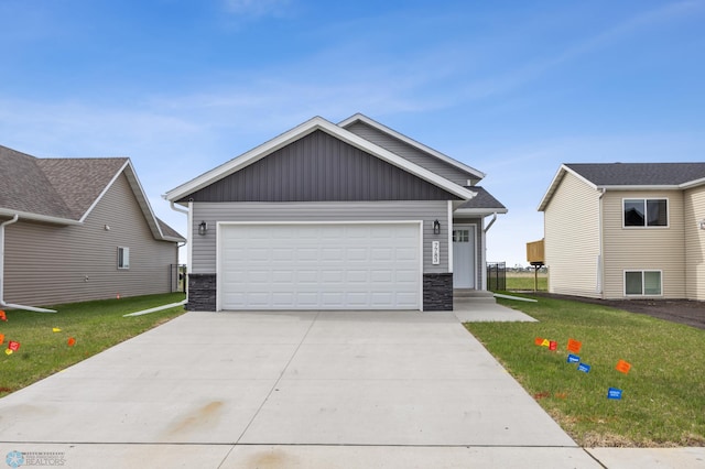 view of front of house featuring stone siding, board and batten siding, driveway, and a front lawn