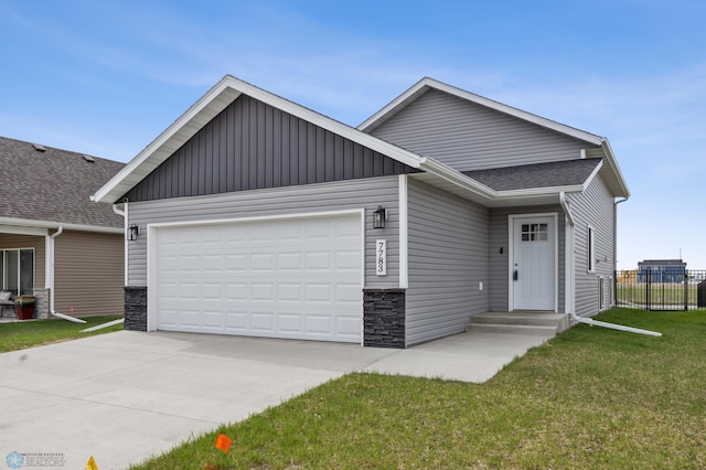 view of front of house with stone siding, a garage, driveway, and board and batten siding