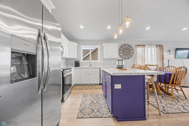kitchen with stainless steel appliances, a kitchen island, a breakfast bar area, white cabinetry, and light wood-style flooring
