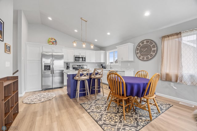 dining room featuring vaulted ceiling, light wood-type flooring, recessed lighting, and baseboards