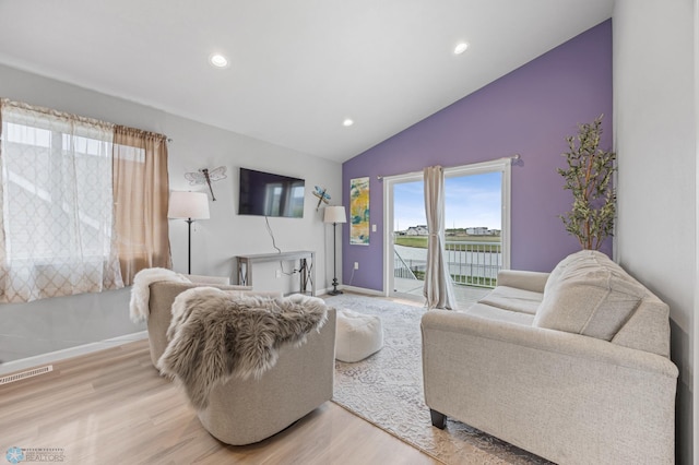 living room featuring vaulted ceiling, light wood-style floors, baseboards, and recessed lighting