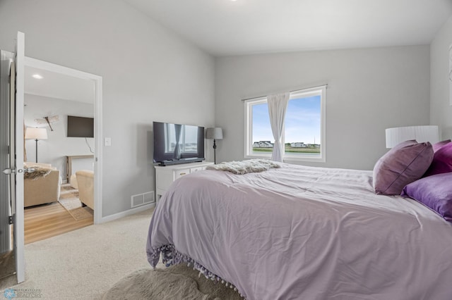 carpeted bedroom with lofted ceiling and baseboards