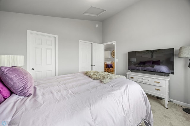 bedroom with attic access, carpet, and lofted ceiling