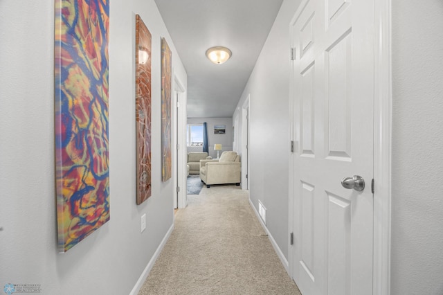 corridor with light colored carpet and baseboards