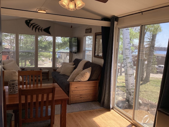 sunroom featuring vaulted ceiling, wood finished floors, and plenty of natural light