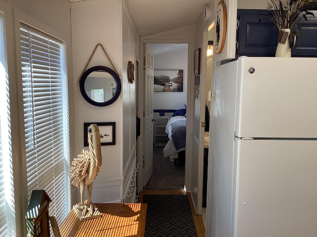 hallway with vaulted ceiling and plenty of natural light