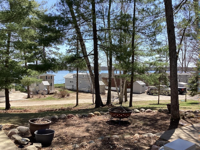 view of yard with an outdoor fire pit, a storage unit, and an outbuilding
