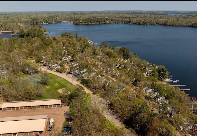 view of property location with a nearby body of water and a forest