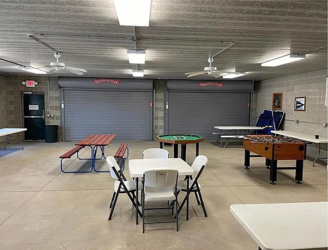 rec room featuring finished concrete floors and ceiling fan