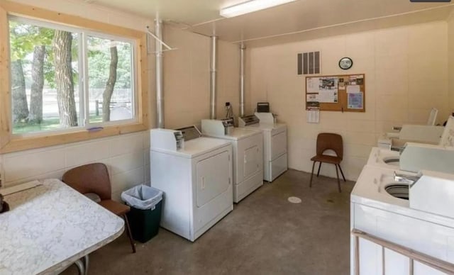 community laundry featuring tile walls and independent washer and dryer