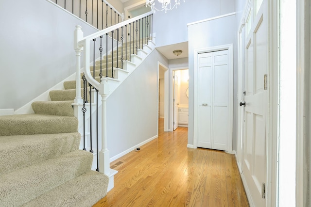 1900 Vernon Dr S, Minnetonka, MN 55305 - entrance foyer featuring stairway, light wood-style floors, a chandelier, a towering ceiling, and baseboards