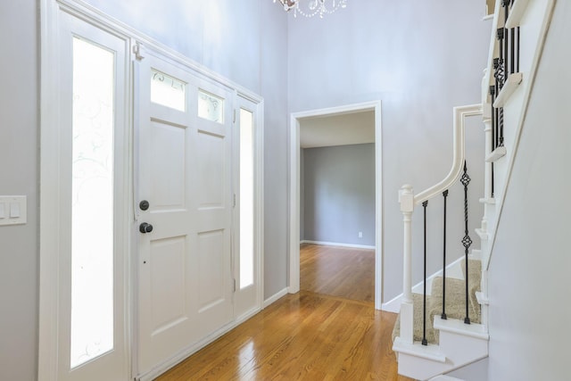 1900 Vernon Dr S, Minnetonka, MN 55305 - entrance foyer with light wood-type flooring, stairs, a chandelier, baseboards, and a towering ceiling