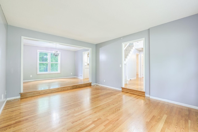 1900 Vernon Dr S, Minnetonka, MN 55305 - empty room with a chandelier, light wood finished floors, baseboards, and stairs