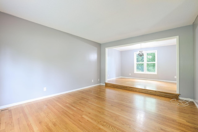 1900 Vernon Dr S, Minnetonka, MN 55305 - empty room with light wood finished floors, a chandelier, and baseboards