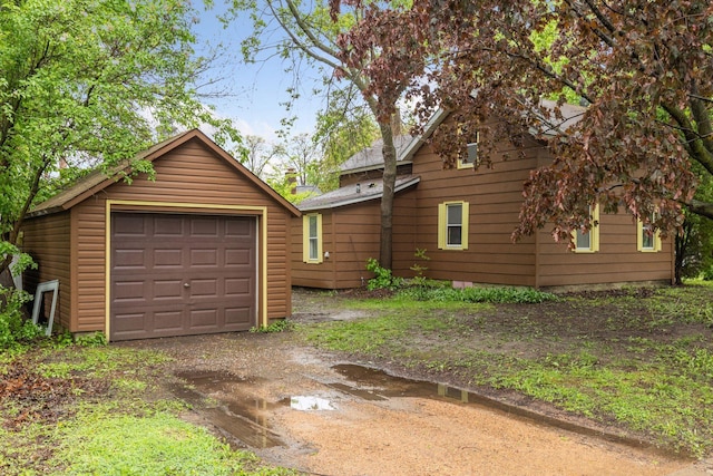 100 2nd St S, Delano, MN 55328 - view of side of property with an outbuilding, a detached garage, and dirt driveway