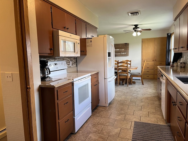 2250 18th Ave, Windom, MN 56101 - kitchen with white appliances, a ceiling fan, stone finish flooring, and light countertops