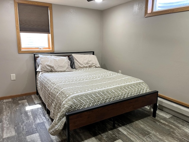 2250 18th Ave, Windom, MN 56101 - bedroom with wood finished floors, multiple windows, and baseboard heating