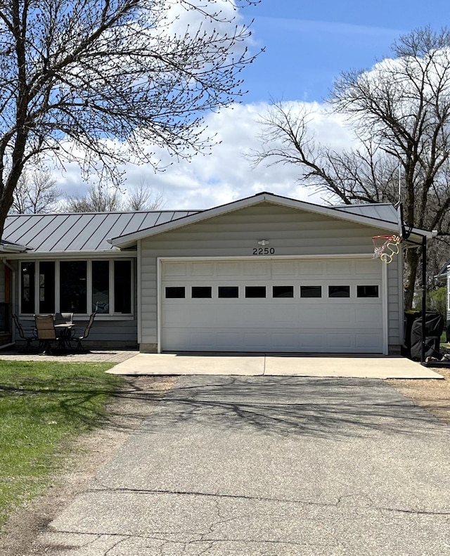2250 18th Ave, Windom, MN 56101 - view of front facade featuring asphalt driveway, a garage, and a standing seam roof