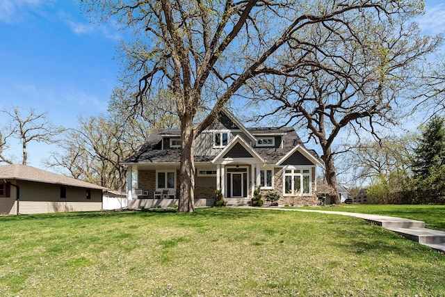 view of front of house featuring a front lawn and stone siding