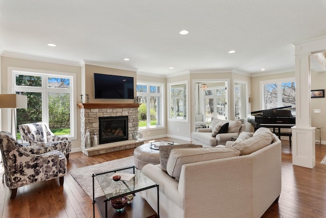 204 8th Ave S, Princeton, MN 55371 - living room featuring dark wood-style floors, a fireplace, recessed lighting, crown molding, and ornate columns