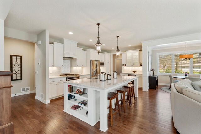 204 8th Ave S, Princeton, MN 55371 - kitchen with backsplash, a breakfast bar area, recessed lighting, white cabinetry, and dark wood-type flooring