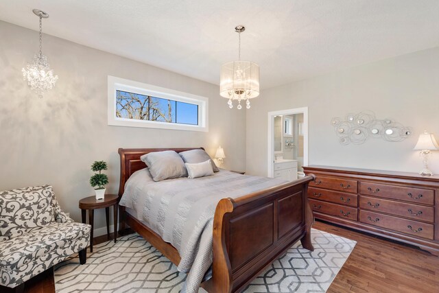 204 8th Ave S, Princeton, MN 55371 - bedroom featuring a chandelier, wood finished floors, and ensuite bath