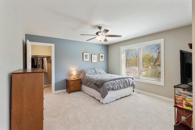 204 8th Ave S, Princeton, MN 55371 - bedroom with light carpet, a spacious closet, ceiling fan, and a textured ceiling