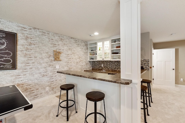 204 8th Ave S, Princeton, MN 55371 - kitchen with light carpet, open shelves, a breakfast bar area, dark countertops, and recessed lighting