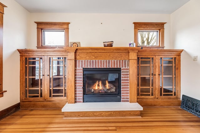 interior space featuring baseboards, a fireplace, and wood finished floors
