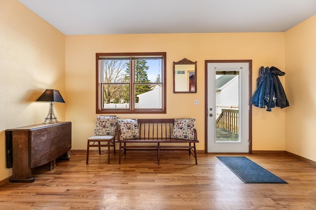 doorway with wood finished floors and baseboards