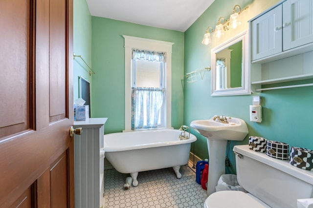 bathroom with a soaking tub and toilet
