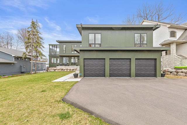 4919 Three Points Blvd, Mound, MN 55364 - back of house with a garage, asphalt driveway, a yard, and stucco siding
