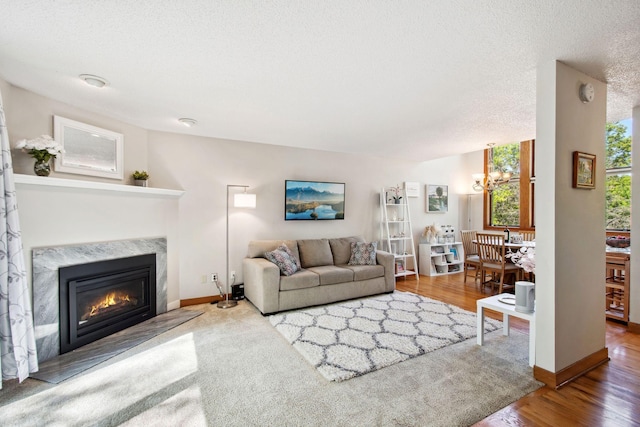 3664 Abbey Way Unit C, Eagan, MN 55123 - living area with wood finished floors, a chandelier, a premium fireplace, a textured ceiling, and baseboards