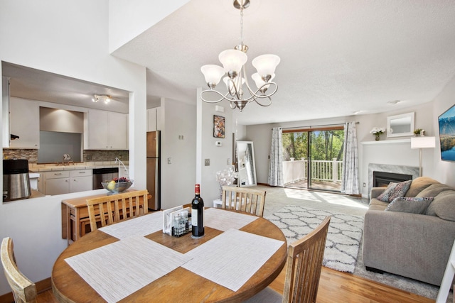 3664 Abbey Way Unit C, Eagan, MN 55123 - dining space featuring a chandelier, a premium fireplace, and light wood finished floors