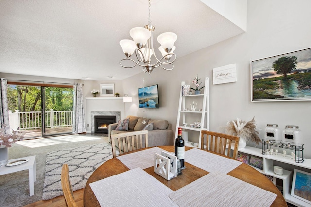 3664 Abbey Way Unit C, Eagan, MN 55123 - dining room featuring a chandelier, a premium fireplace, a textured ceiling, and wood finished floors