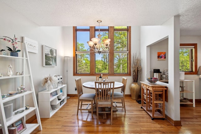 3664 Abbey Way Unit C, Eagan, MN 55123 - dining room with a chandelier, a textured ceiling, wood finished floors, and baseboards