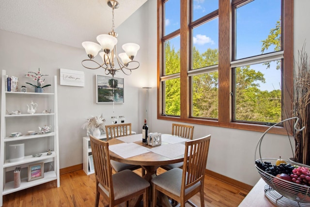 3664 Abbey Way Unit C, Eagan, MN 55123 - dining area featuring light wood-type flooring, a chandelier, baseboards, and a towering ceiling