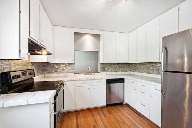3664 Abbey Way Unit C, Eagan, MN 55123 - kitchen with appliances with stainless steel finishes, a sink, under cabinet range hood, light wood finished floors, and tile counters