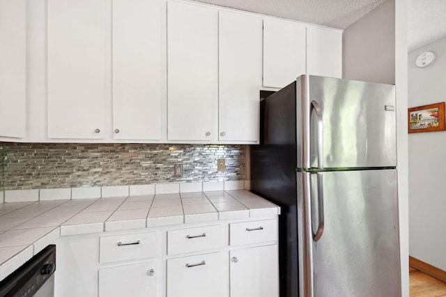 3664 Abbey Way Unit C, Eagan, MN 55123 - kitchen featuring appliances with stainless steel finishes, tile countertops, white cabinetry, tasteful backsplash, and a textured ceiling