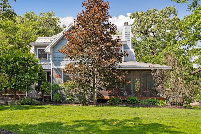 16710 Edgewood Ave, Wayzata, MN 55391 - rear view of house with a sunroom, a lawn, a chimney, and a metal roof