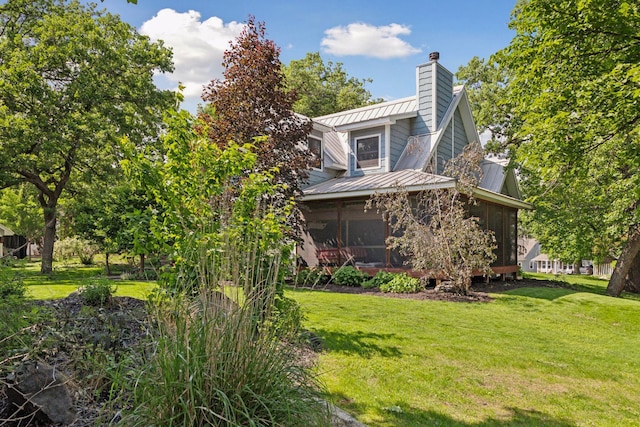 16710 Edgewood Ave, Wayzata, MN 55391 - view of property exterior with a sunroom, a chimney, a yard, a metal roof, and a standing seam roof