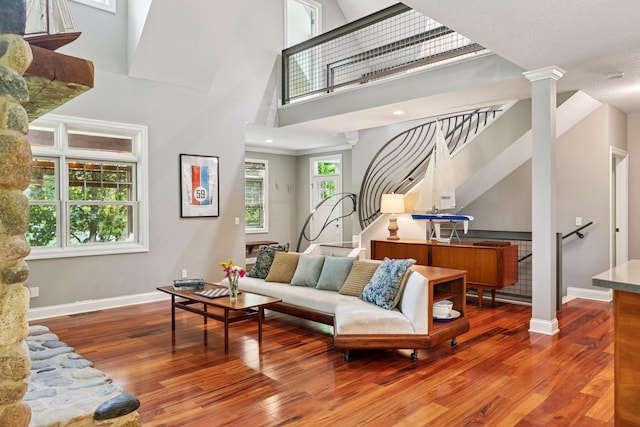 16710 Edgewood Ave, Wayzata, MN 55391 - living room featuring wood finished floors, stairway, a high ceiling, and decorative columns