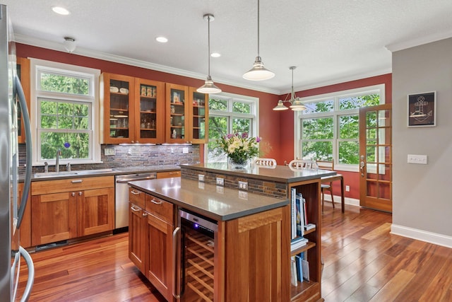16710 Edgewood Ave, Wayzata, MN 55391 - kitchen featuring appliances with stainless steel finishes, wine cooler, brown cabinetry, ornamental molding, and dark countertops