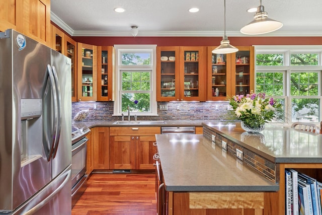 16710 Edgewood Ave, Wayzata, MN 55391 - kitchen with appliances with stainless steel finishes, brown cabinetry, ornamental molding, backsplash, and glass insert cabinets