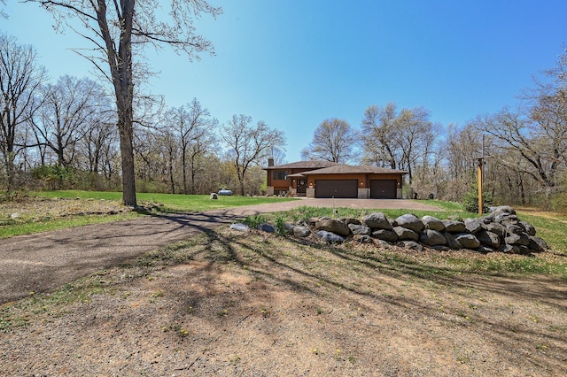 view of yard with a garage and driveway