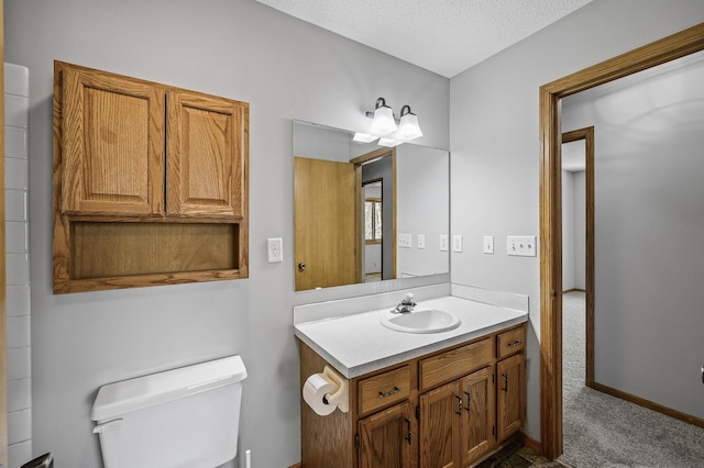 bathroom with toilet, vanity, and a textured ceiling
