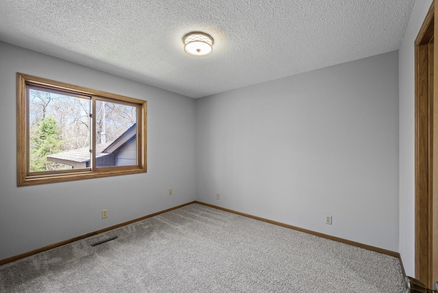 carpeted spare room featuring a textured ceiling, baseboards, and visible vents
