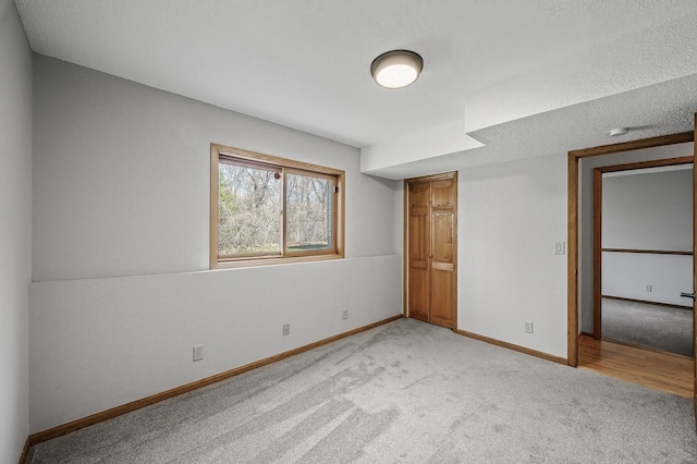 unfurnished bedroom featuring light carpet and baseboards
